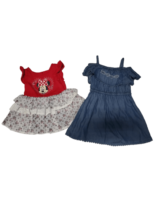 Children's clothing including a red shirt with a floral design, a navy blue dress, and a floral headband on a white background.