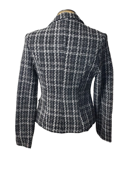Black and white checkered blazer on a mannequin against a white background