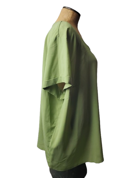 Green shirt on a mannequin against a white background