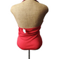 Mannequin wearing a red top and beige vest on a white background