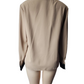 Beige jacket with black trim on a mannequin against a white background
