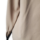Close-up of a beige garment with a black trim on a white background