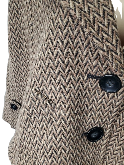 Close-up of a textured fabric with a herringbone pattern and black buttons.