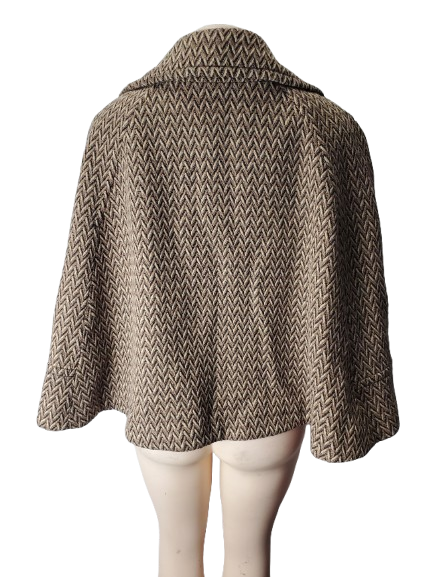 Brown patterned cape on a mannequin against a white background