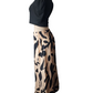 Mannequin wearing a black top and patterned beige skirt on a white background