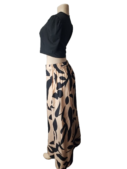 Mannequin wearing a black top and patterned beige skirt on a white background