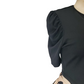 Black top with puff sleeves on a mannequin against a white background