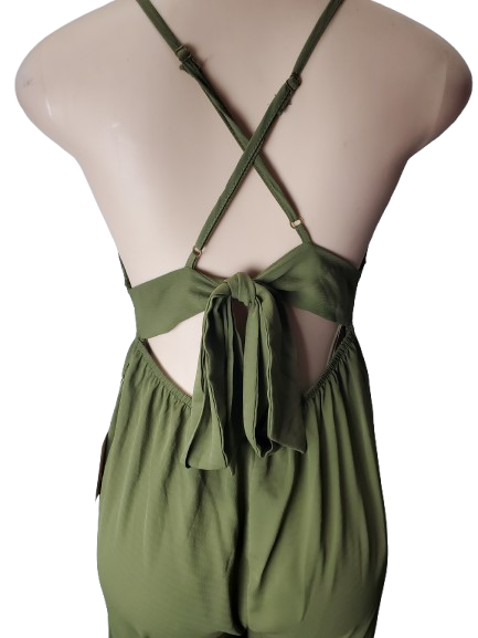 Green jumpsuit with criss-cross straps on a mannequin against a white background
