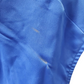 Close-up of a blue fabric with a stain on a white background