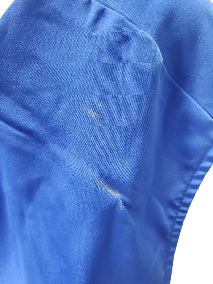 Close-up of a blue fabric with a stain on a white background