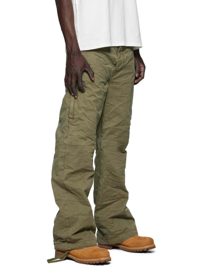Person wearing green pants and brown shoes on a white background