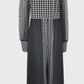 Black and white checkered jumpsuit with sheer sleeves on a mannequin against a white background